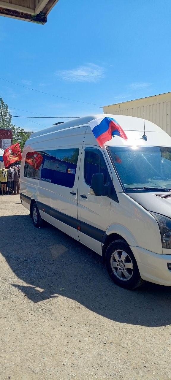 Белый пассажирский микроавтобус с флагами